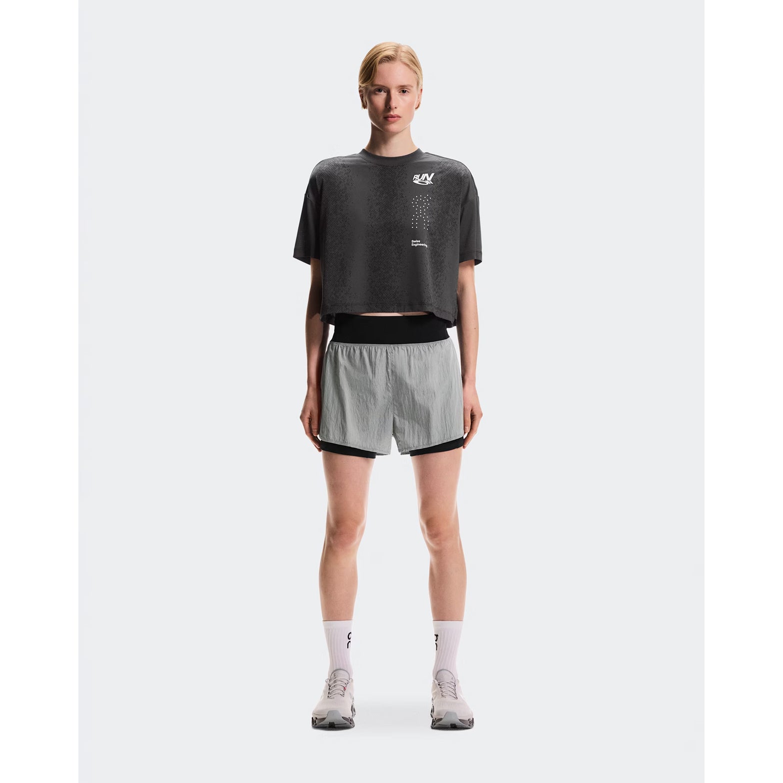 Women's On Performance Volt Shorts Glacier full body front view on female runner showing dual-layer design with windproof outer and moisture-wicking inner for everyday training