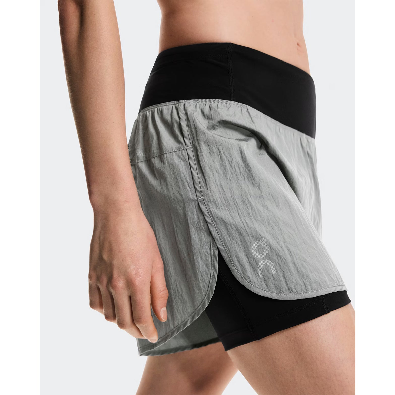 Women's On Performance Volt Shorts Glacier side view on female runner showing dual-layer construction with windproof iridescent outer, four-way stretch inner tights and moisture-wicking On DryTec technology