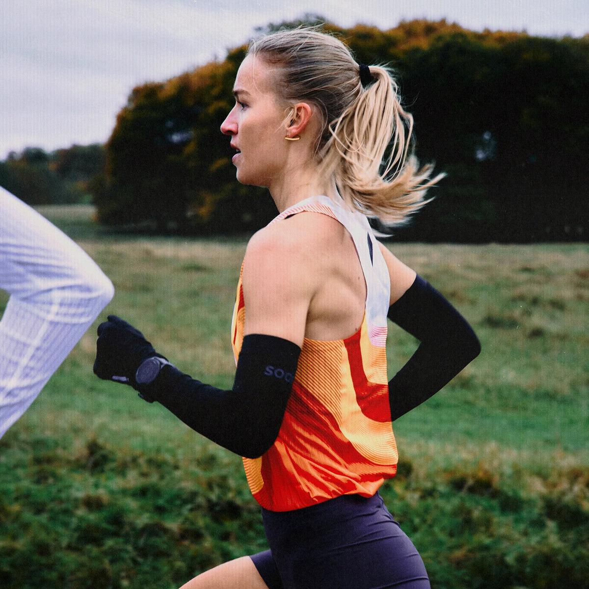Women's Soar Race Vest Black White Dot worn by female runner in motion showing cutaway design and aerodynamic close fit during running