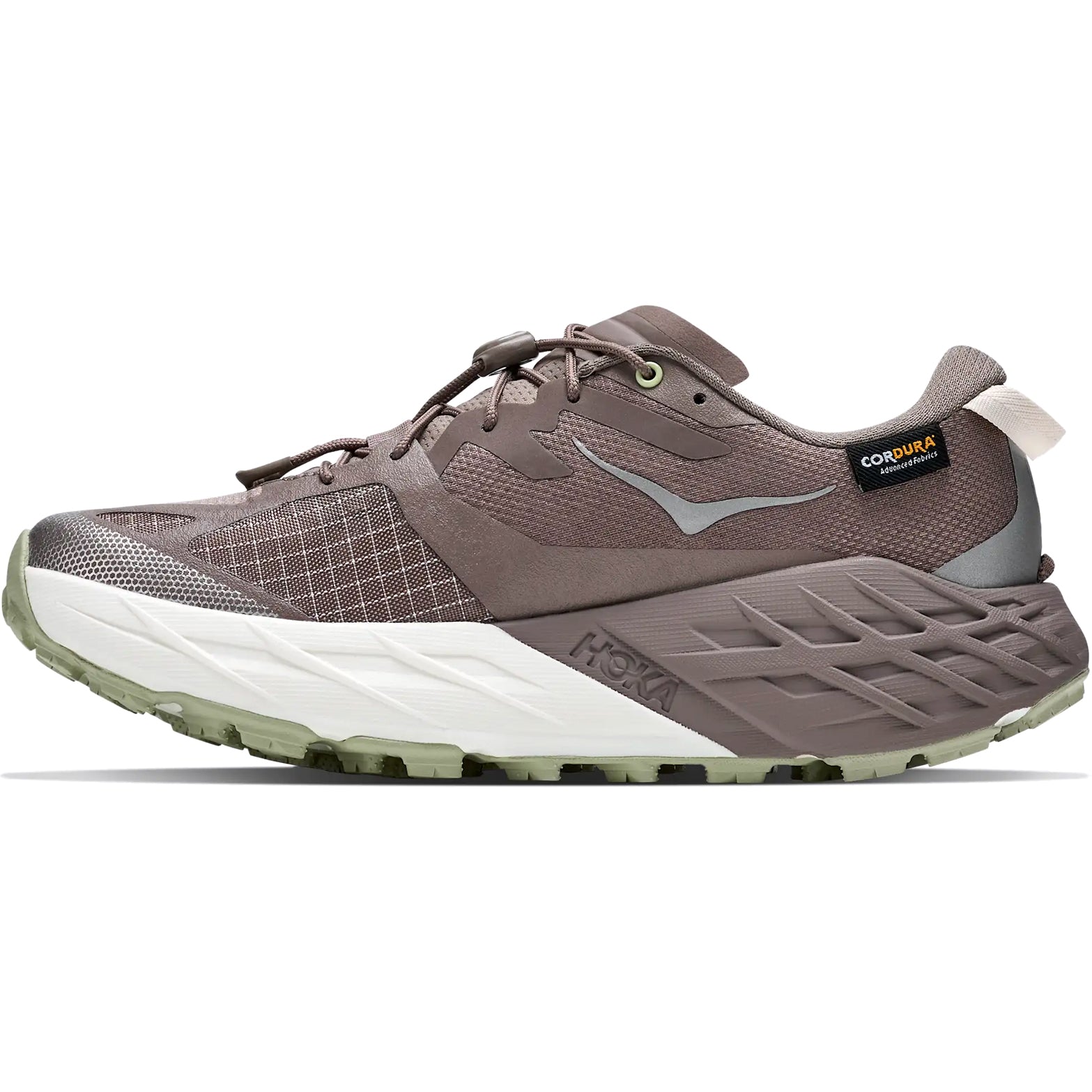 The Hoka Women’s Speedgoat 7 GORE-TEX Trail Running Shoes in Pebble Grey and Alabaster feature a mesh and synthetic upper, a thick white and light green sole, waterproof trail shoe construction, and a small Cordura tag near the heel.