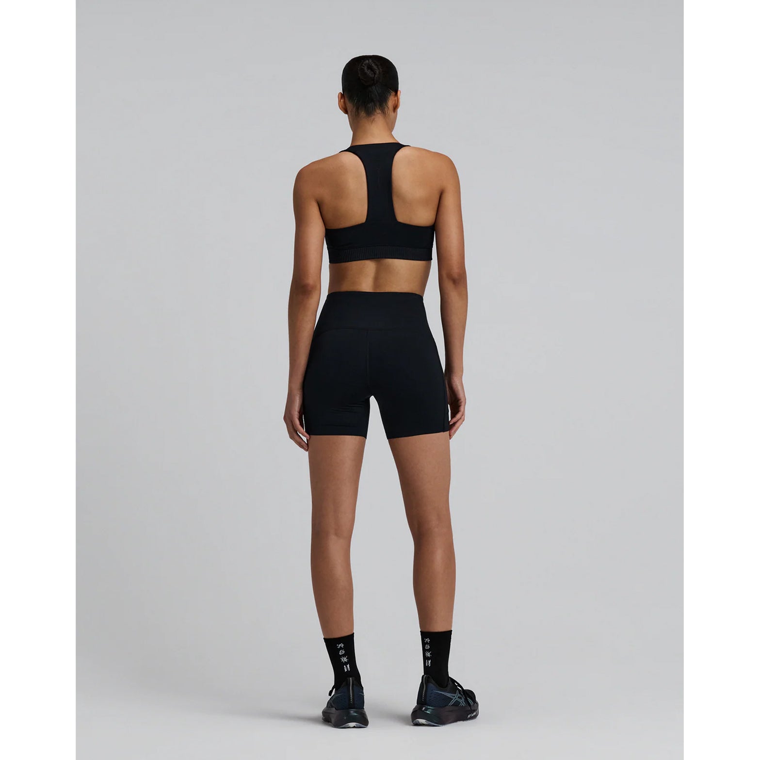 Women's Bandit Stamina-V High Waist 5 Inch Compression Shorts Black full body back view on female runner showing waterproof phone pockets and Stamina-V volcanic fabric technology