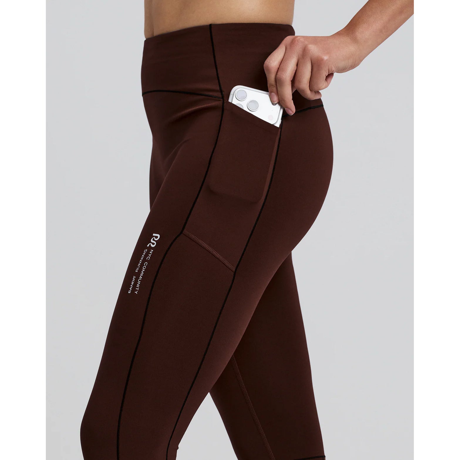 Women's Bandit Stamina-V High Waist Leggings side view with phone in waterproof pocket showing sweat-proof liner protection and secure storage during running