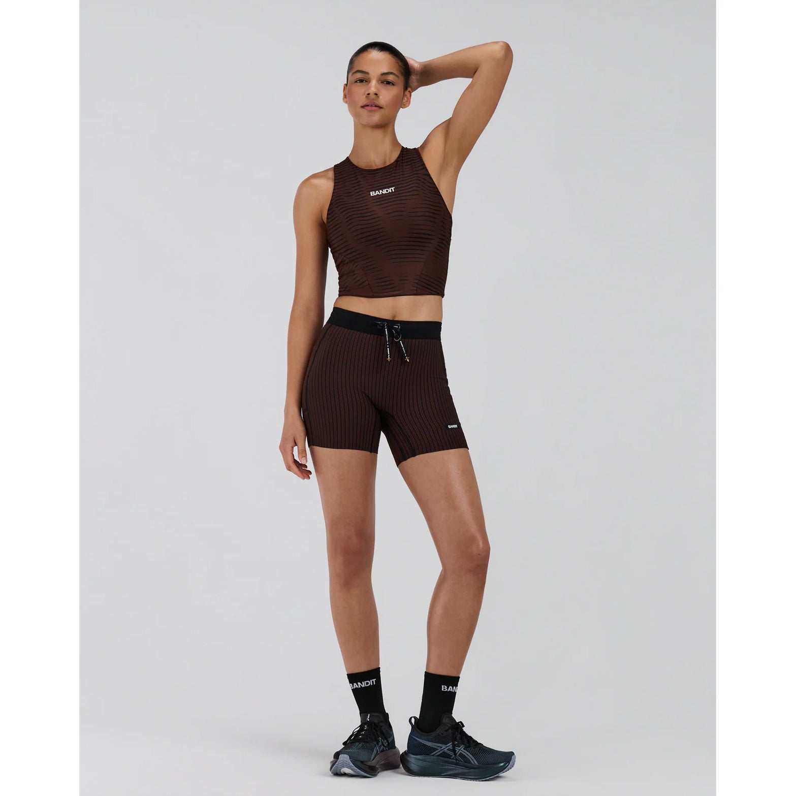 Women's Bandit Stamina Race Crop Organic Stripe Cacao full body front view on female runner showing classic race crop silhouette with built-in bra and moisture-wicking Stamina fabric