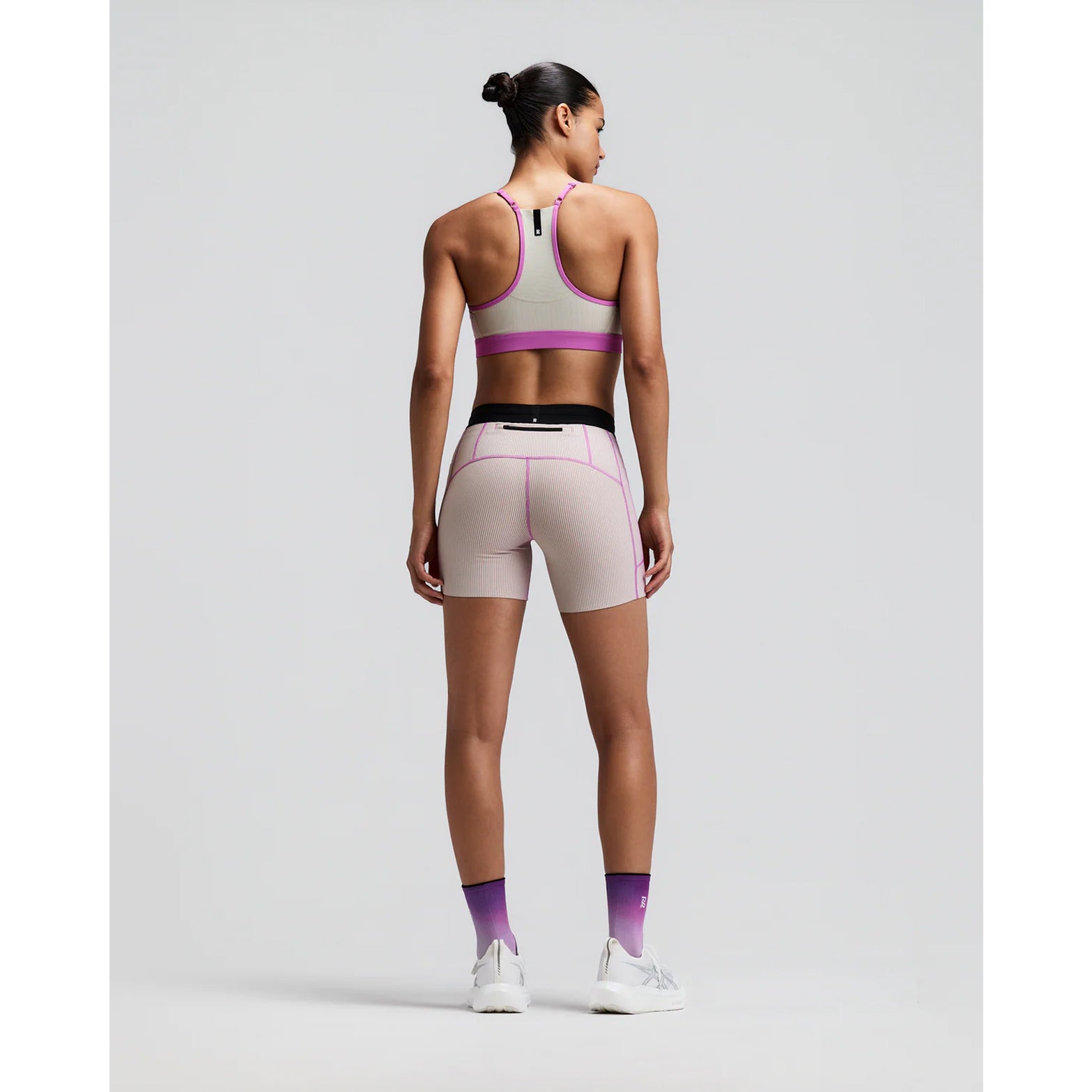 Women's Bandit Striped Cadence 5 Inch Compression Shorts Plaster Orchid back full body view on female runner showing grip tape hems with back zipper pocket and ultra-compressive Striped Cadence construction for long-distance running