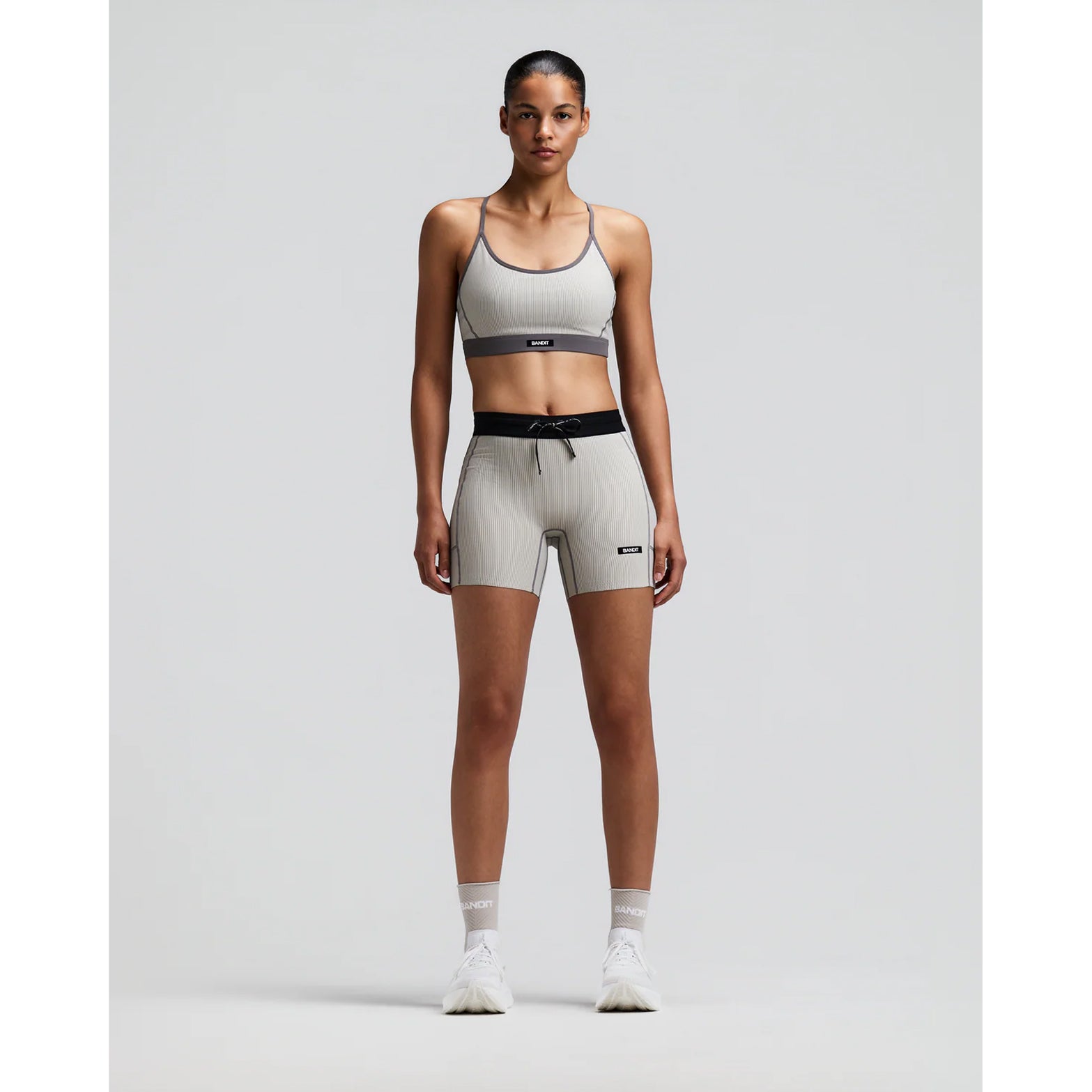 Women's Bandit Striped Cadence 5 Inch Compression Shorts Plaster Slate front full body view on female runner showing 5-inch inseam with ultra-compressive ribbed knit and five-pocket storage system for racing and marathon training