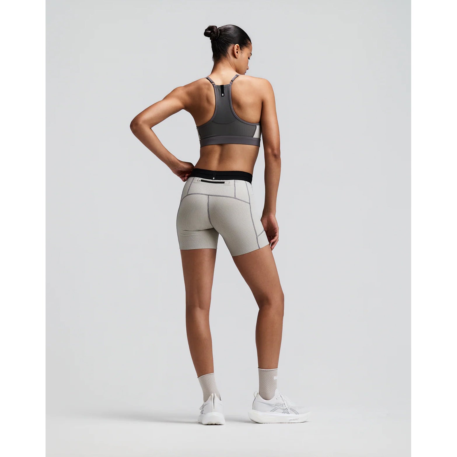 Women's Bandit Striped Cadence 5 Inch Compression Shorts Plaster Slate back full body view on female runner showing grip tape hems with back zipper pocket and ultra-compressive Striped Cadence construction for long-distance running