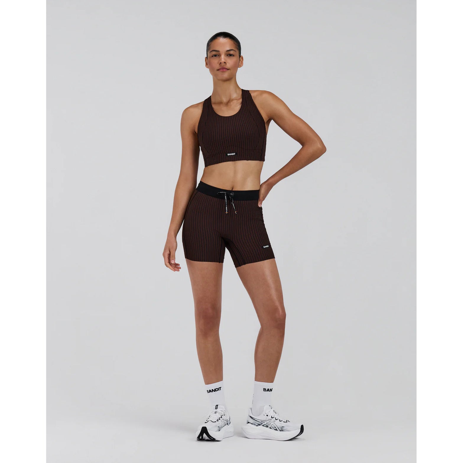 Bandit Striped Cadence Longline Bra women's in Cacao / Black — full body front view worn on model showing longline silhouette, cacao and black Striped Cadence™ ribbed knit and double-layer support in motion