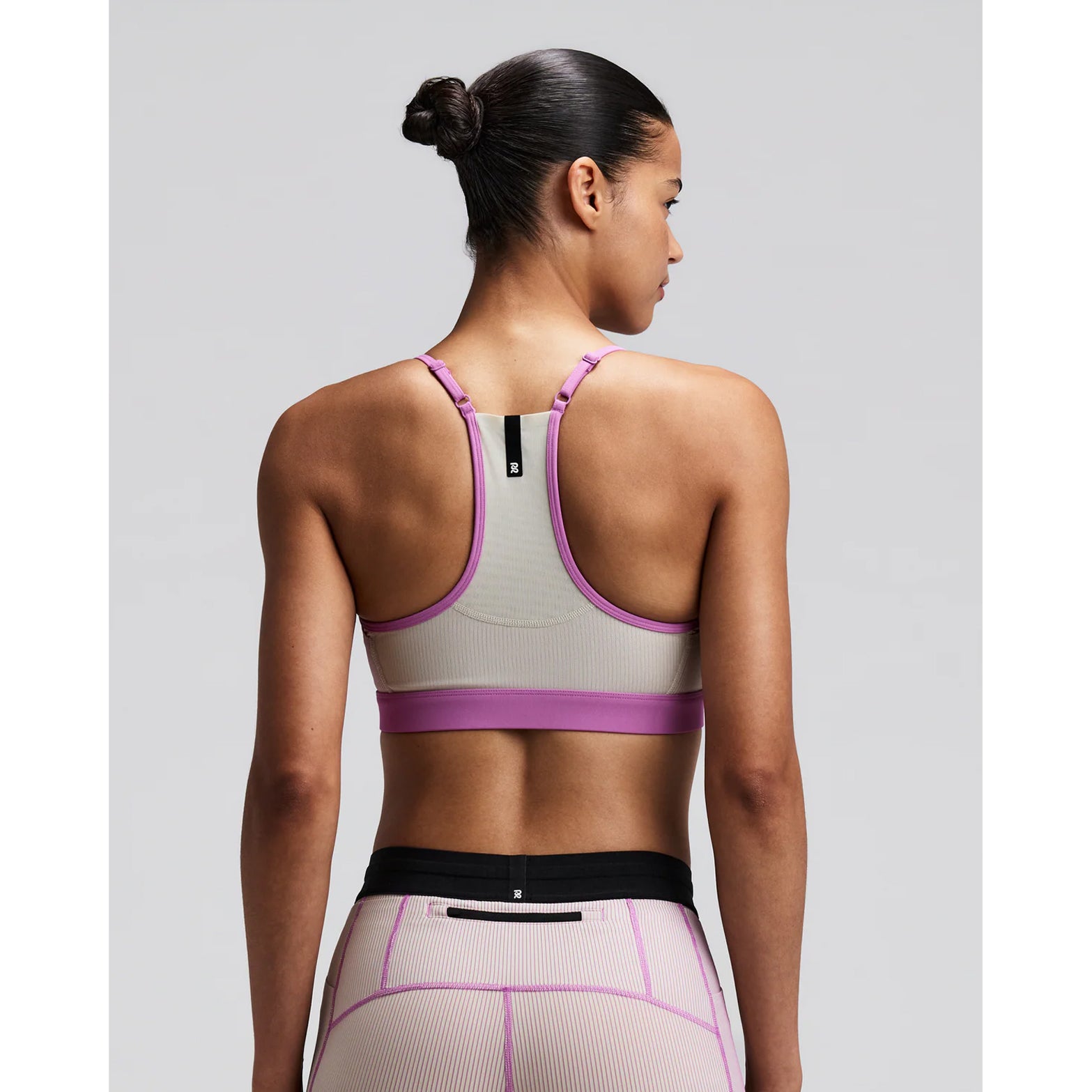 Women's Bandit Striped Cadence Strappy Bra Plaster Orchid back view on female runner showing Powermesh back panel with waterproof centre back phone pocket and reflective details for low-light visibility