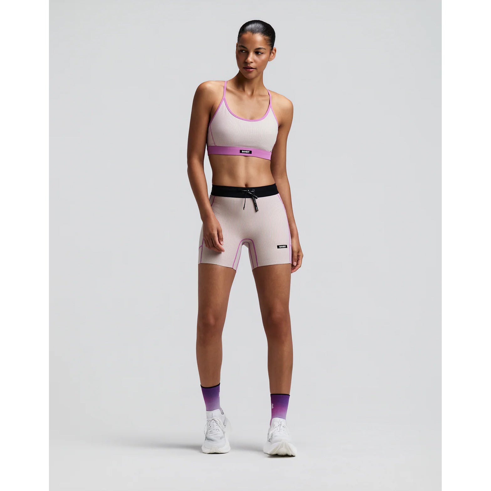 Women's Bandit Striped Cadence Strappy Bra Plaster Orchid front full body view on female runner showing adjustable straps with Striped Cadence ribbed compression and three-pocket system for road running and racing