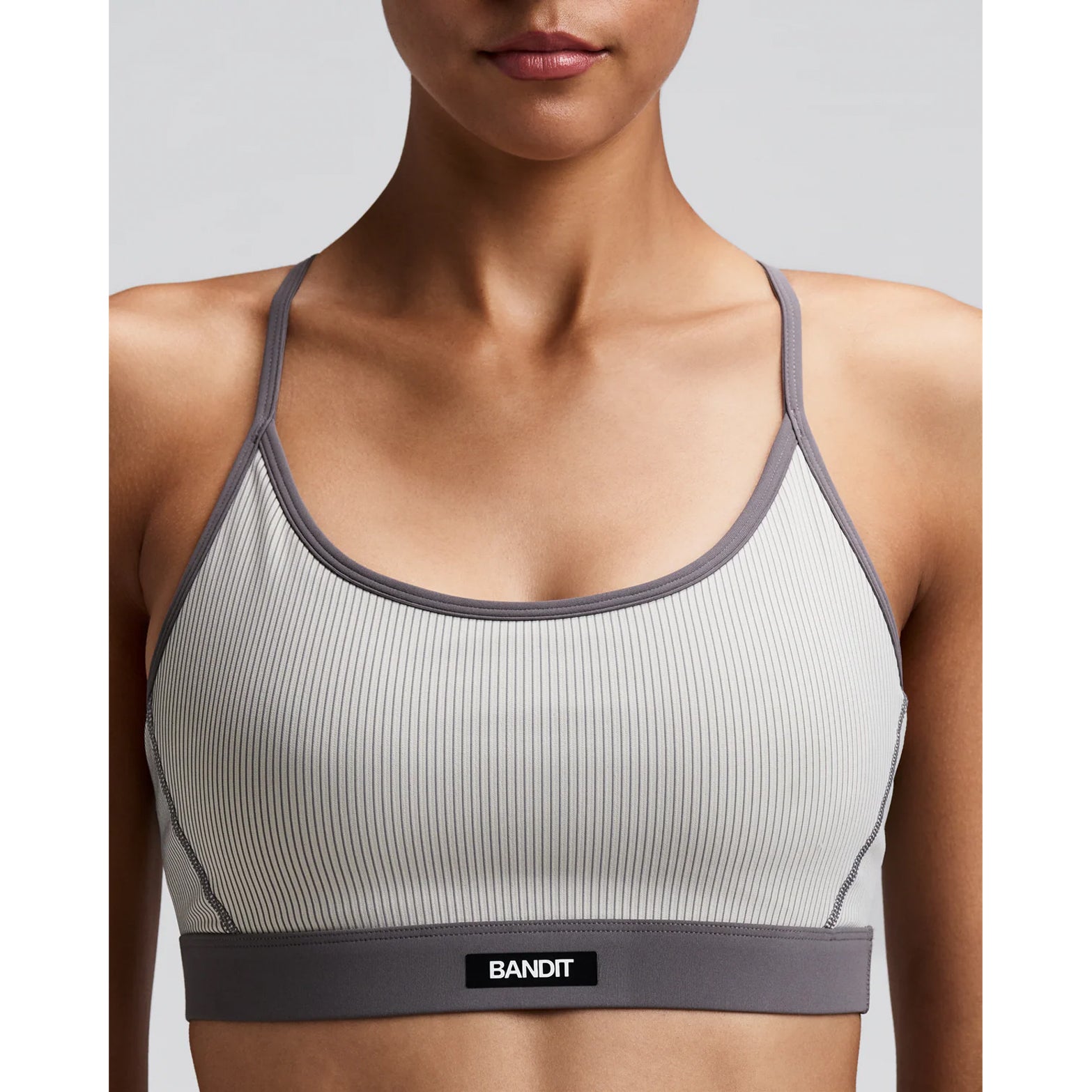 Women's Bandit Striped Cadence Strappy Bra Plaster Slate close-up of front showing Striped Cadence ribbed compression with Bandit branding at centre chest and Vanisher band at hem