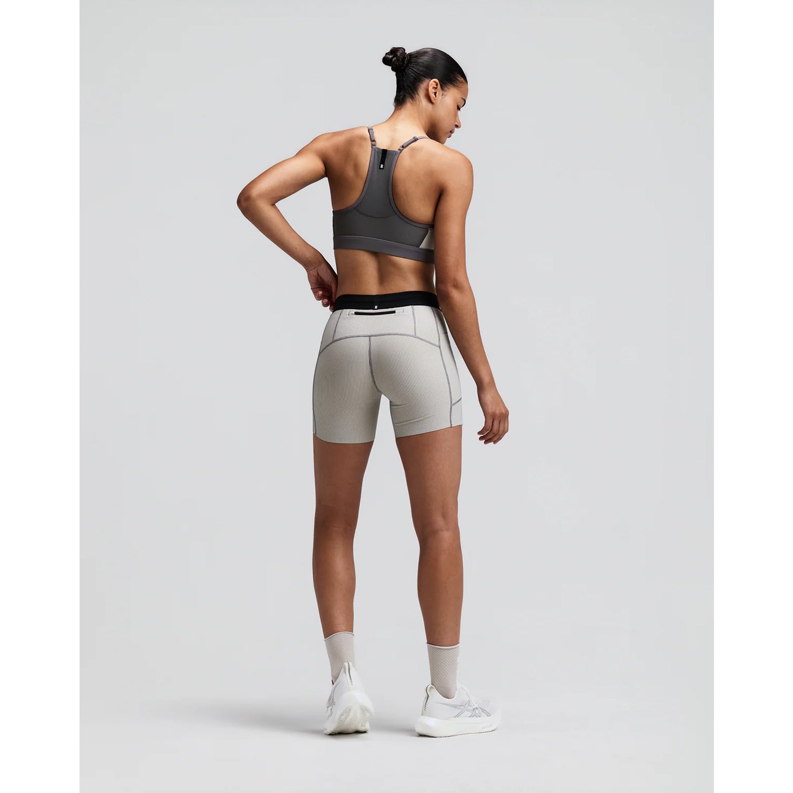 Women's Bandit Striped Cadence Strappy Bra Plaster Slate back full body view on female runner showing Powermesh back panel with waterproof phone pocket and Vanisher band for comfortable race day performance