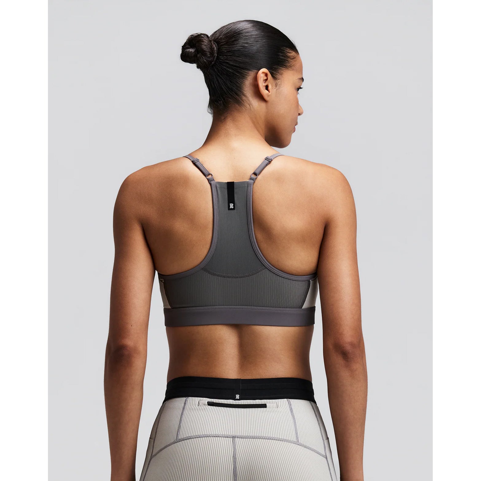 Women's Bandit Striped Cadence Strappy Bra Plaster Slate back view on female runner showing Powermesh back panel with waterproof centre back phone pocket and reflective details for low-light visibility