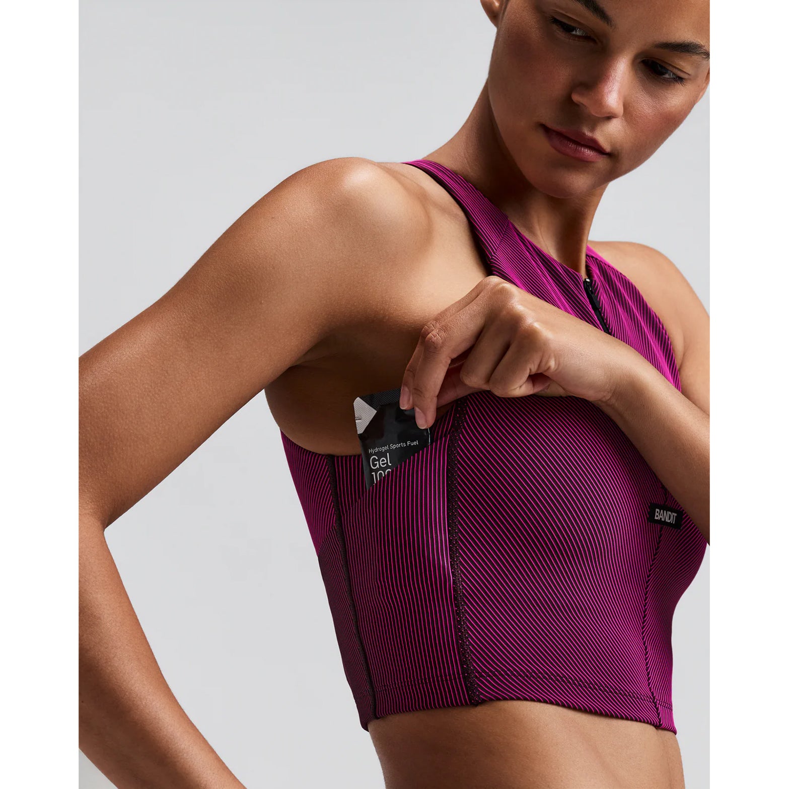 Women's Bandit Striped Cadence Zip Front Race Crop Espresso Azalea close-up of side gel pocket showing secure accessible storage for race day nutrition without bounce during running and racing