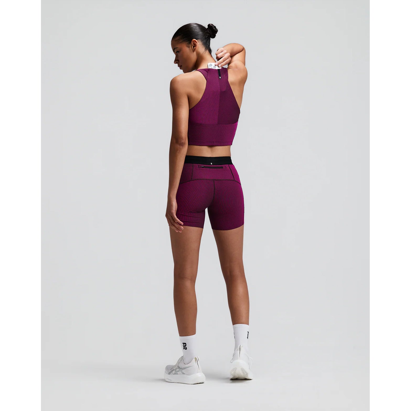 Women's Bandit Striped Cadence Zip Front Race Crop Espresso Azalea back full body view on female runner showing angular racer back with silicone patch and Striped Cadence ribbed compression for race day performance