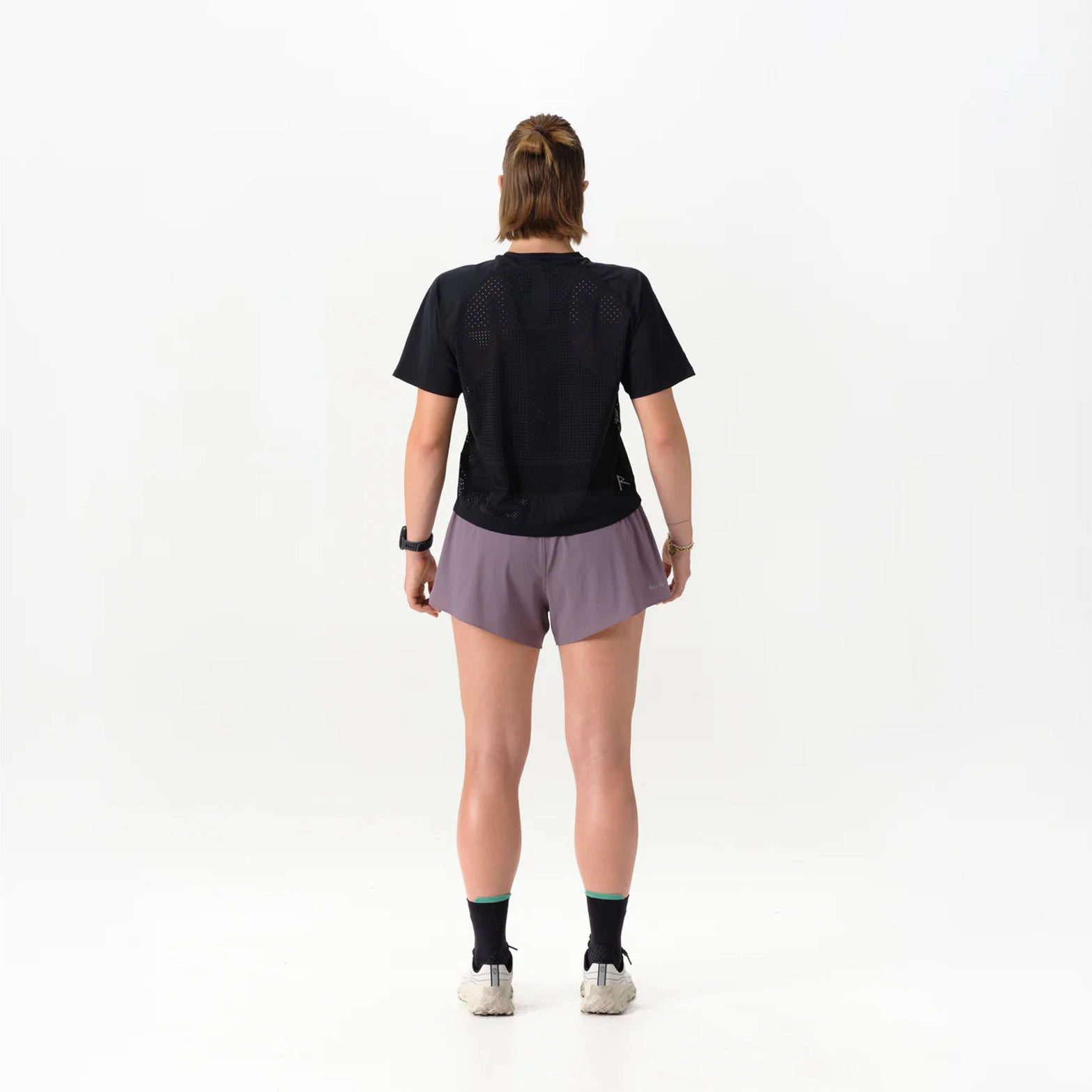 Women's Raide Thermal Dispersion Tee Black back full body view on female runner showing body-mapped centre back perforations with reflective branding and Italian-knit microfibre for evaporative cooling during road running