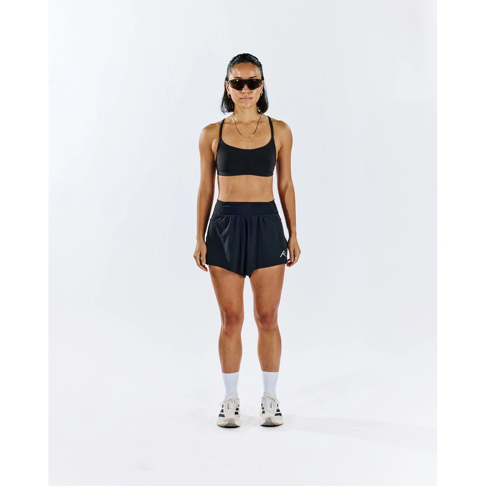 Raide TrailTech Short women's in Black — full body front view worn on model showing 3 inch silhouette, laser-perforated waistband and pocket placement in motion on trail