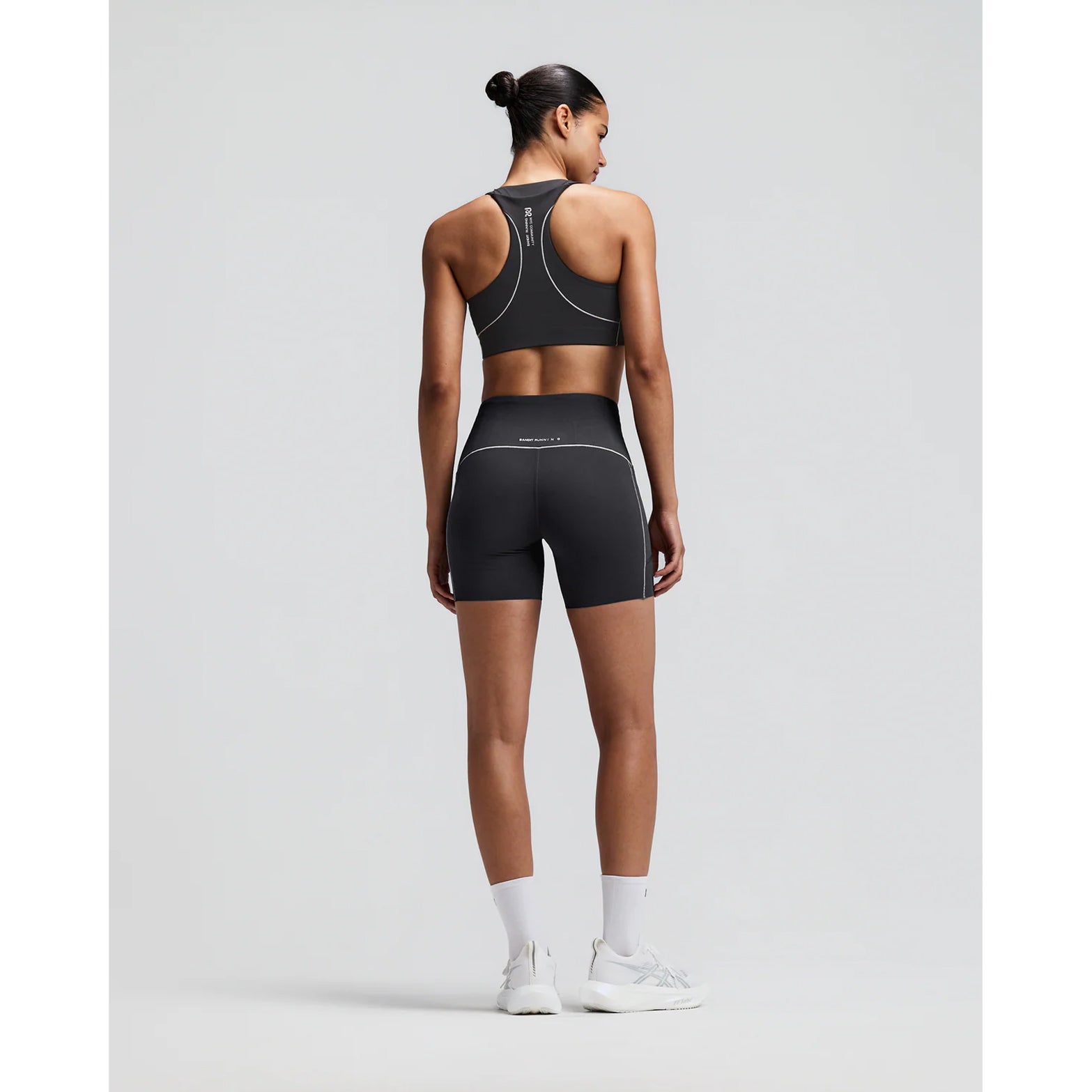 Women's Bandit Vanisher Pop Stitch 5 Inch High Waist Compression Shorts Anthracite back full body view on female runner showing GripDot laser-cut hems with waterproof phone pockets and Vanisher compression construction