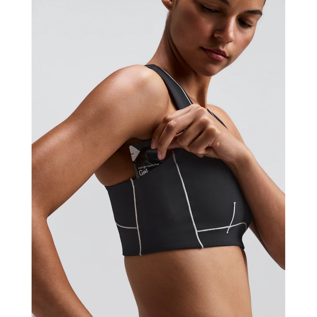 Women's Bandit Vanisher Pop Stitch Arco Run Bra Anthracite side view on female runner showing Vanisher sweat-hiding compression with gel pocket under arm and Pop Stitch armhole detail for comfortable running performance