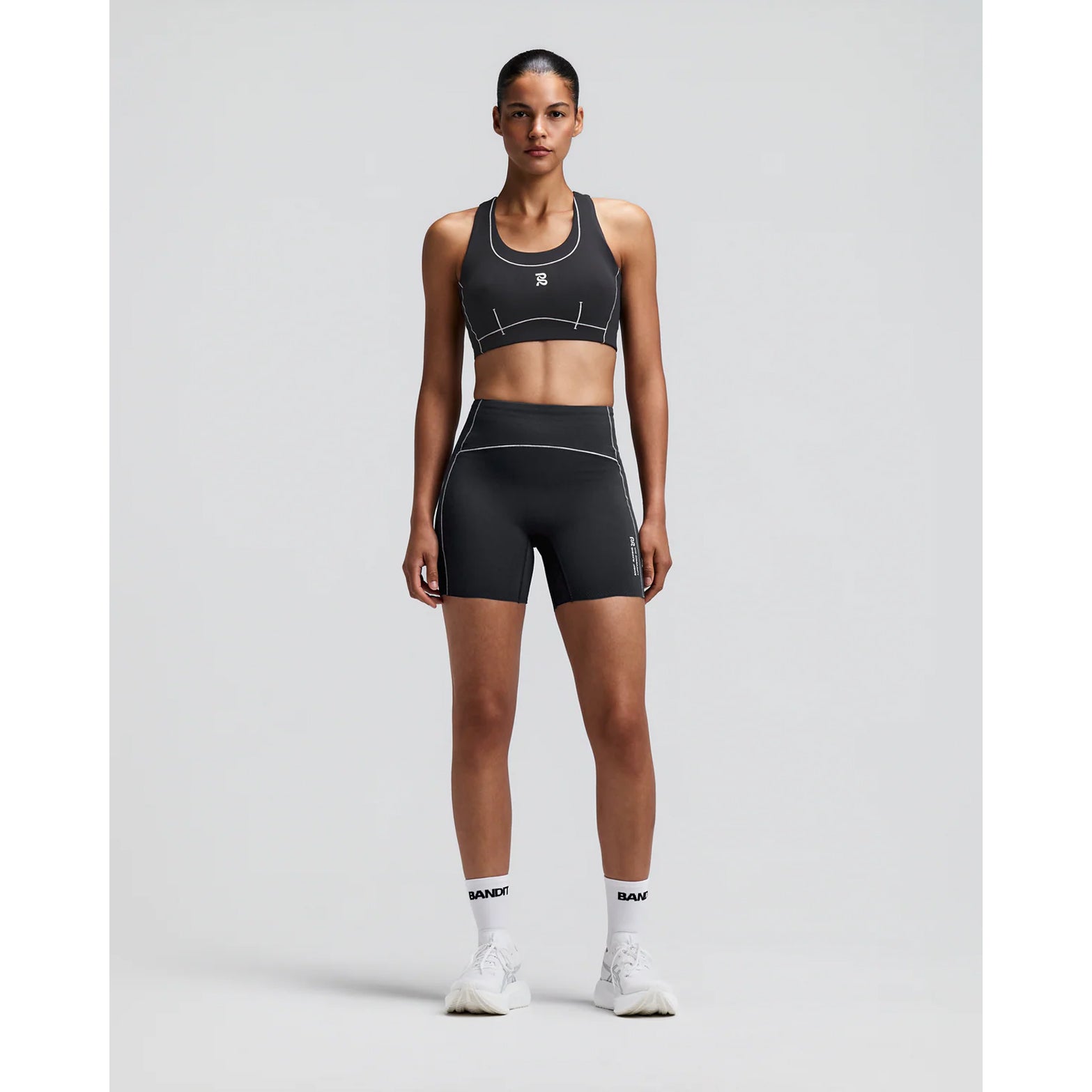 Women's Bandit Vanisher Pop Stitch Arco Run Bra Anthracite front full body view on female runner showing Vanisher compression with Pop Stitch detail and three-pocket system for running and training