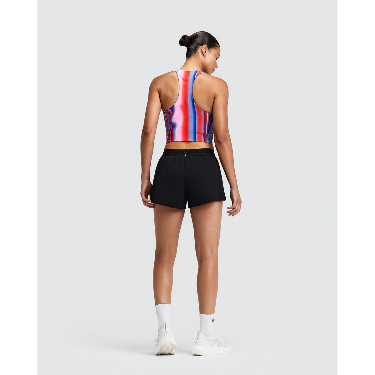 A person viewed from behind wearing a Bandit Women’s Vanisher Race Crop Melted Stripe Gradient and sweat-hiding compression shorts.