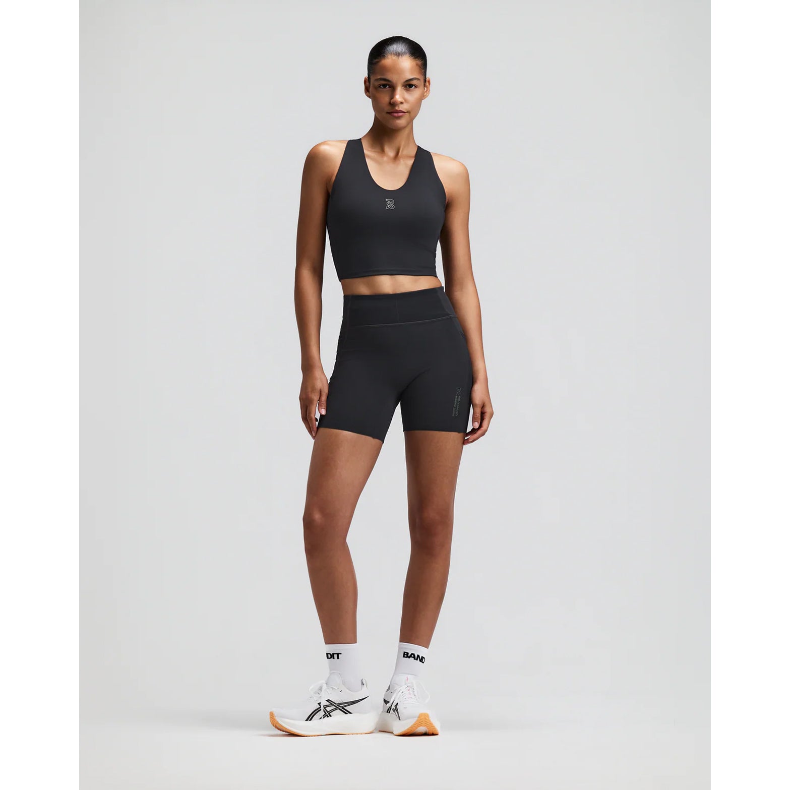 Women's Bandit Vanisher V-Neck Race Crop Top Anthracite front full body view on female runner showing rounded v-neck crop with Vanisher sweat-hiding compression and seven-pocket system for road running and racing