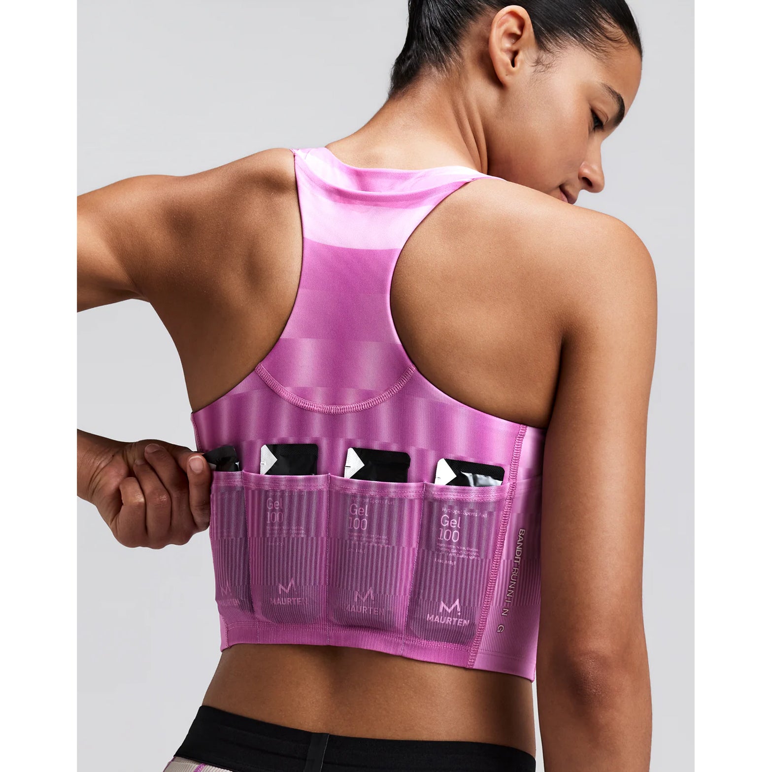 Women's Bandit Vanisher V-Neck Race Crop Top Growing Grid Orchid close-up of pocket system showing three waterproof phone pockets and four gel pockets with zero-bulk design for race day essentials