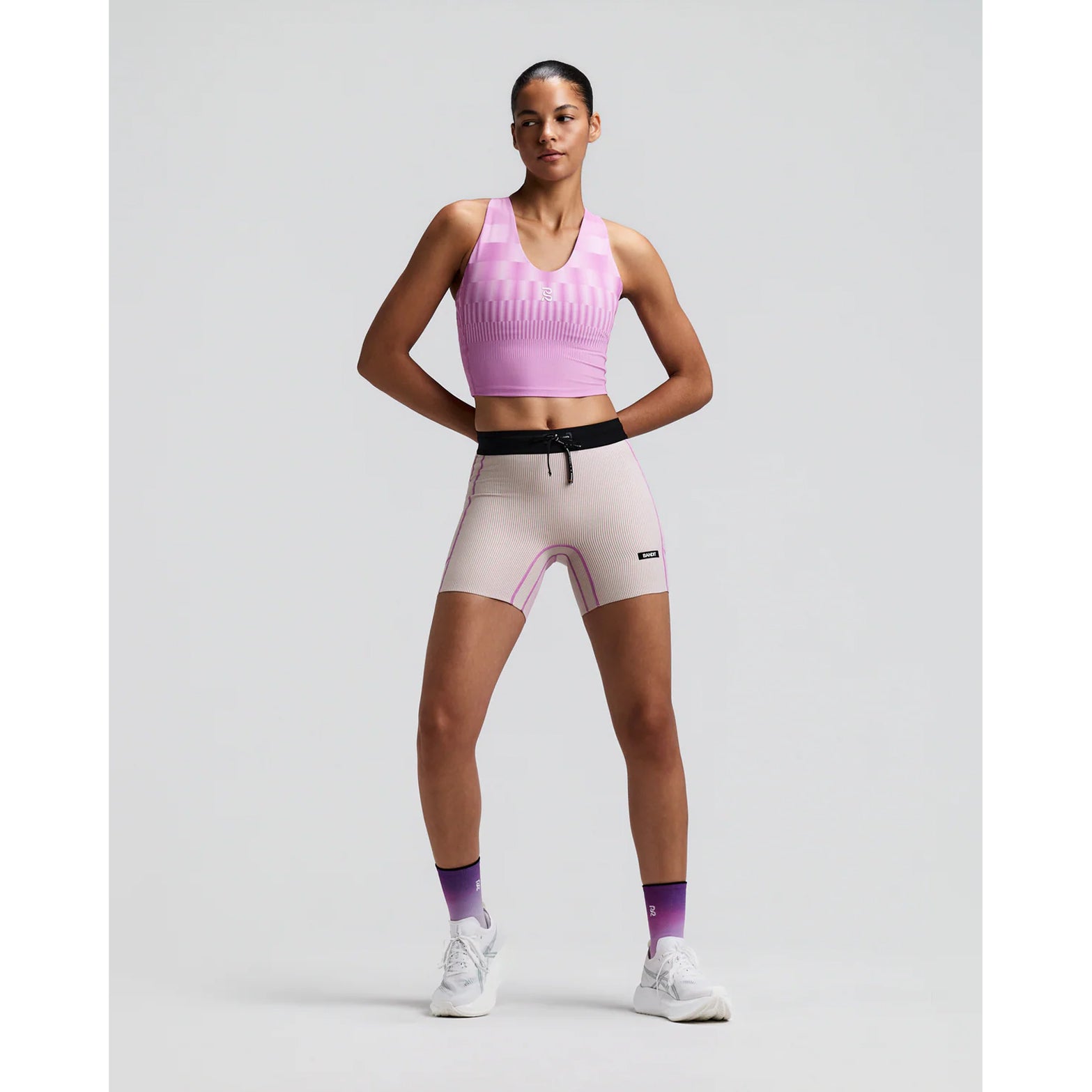 Women's Bandit Vanisher V-Neck Race Crop Top Growing Grid Orchid front full body view on female runner showing rounded v-neck crop with Vanisher sweat-hiding compression and seven-pocket system for road running and racing
