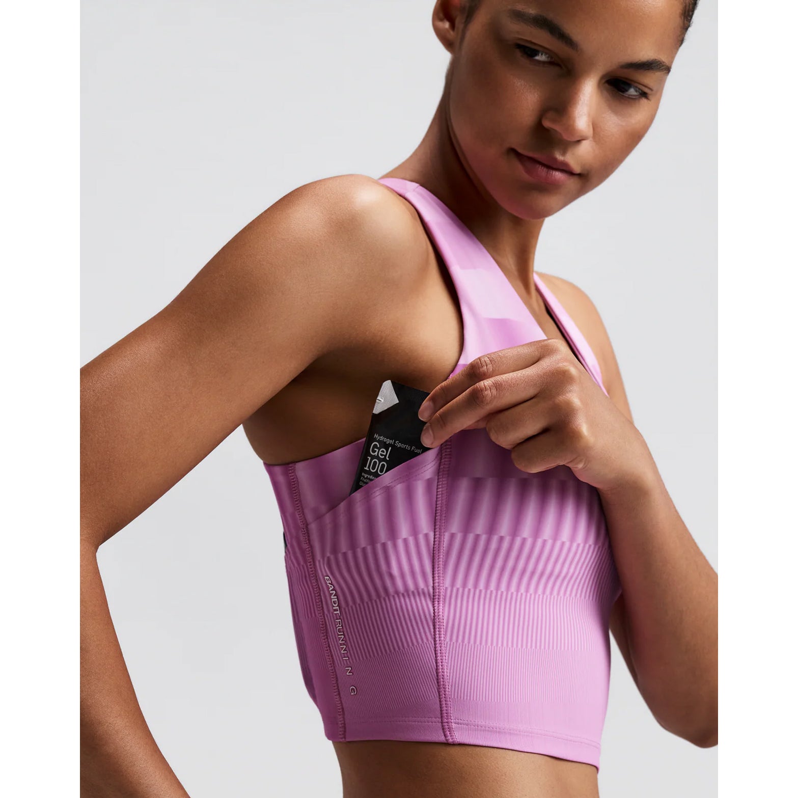 Women's Bandit Vanisher V-Neck Race Crop Top Growing Grid Orchid side view on female runner showing rounded v-neck crop with Vanisher compression, Powermesh back panel and seven-pocket system for comfortable race day performance