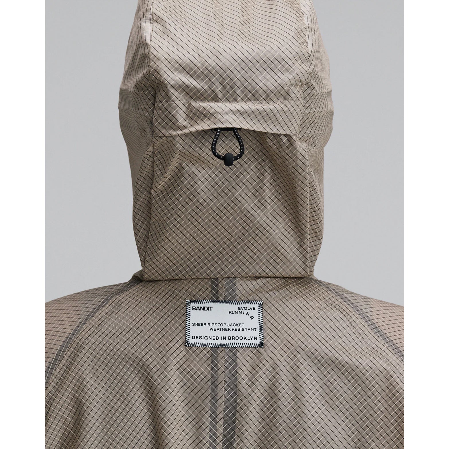 Women's Bandit VeloRip Ultralight Windproof Jacket Oatmeal back view with hood up showing windproof fabric with taped seams and reflective branding for visibility