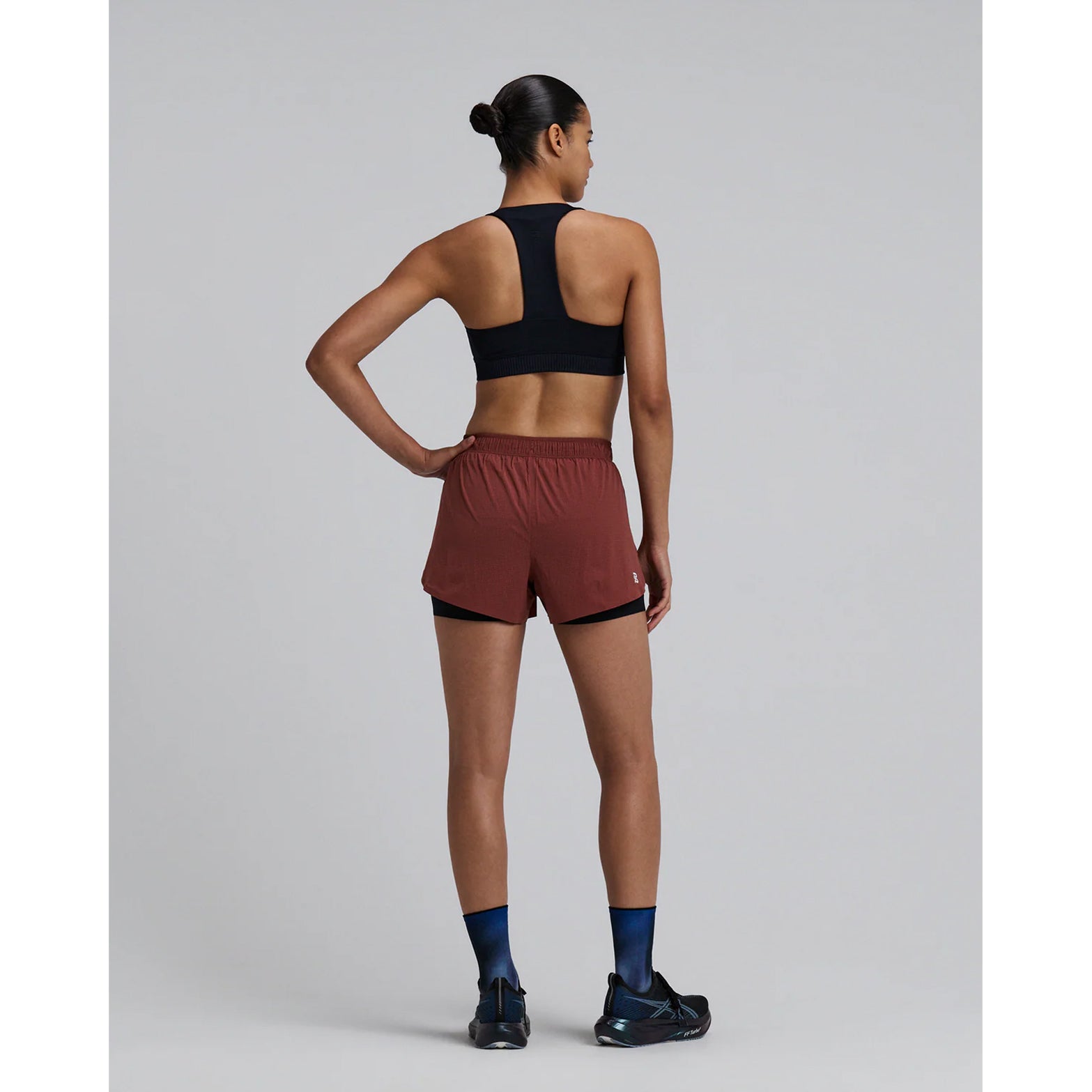 Women's Bandit Vento 2-in-1 Run Short Mahogany Black full body back view on female runner showing 2 waterproof phone pockets, 4 gel pockets and ride-up prevention grip technology