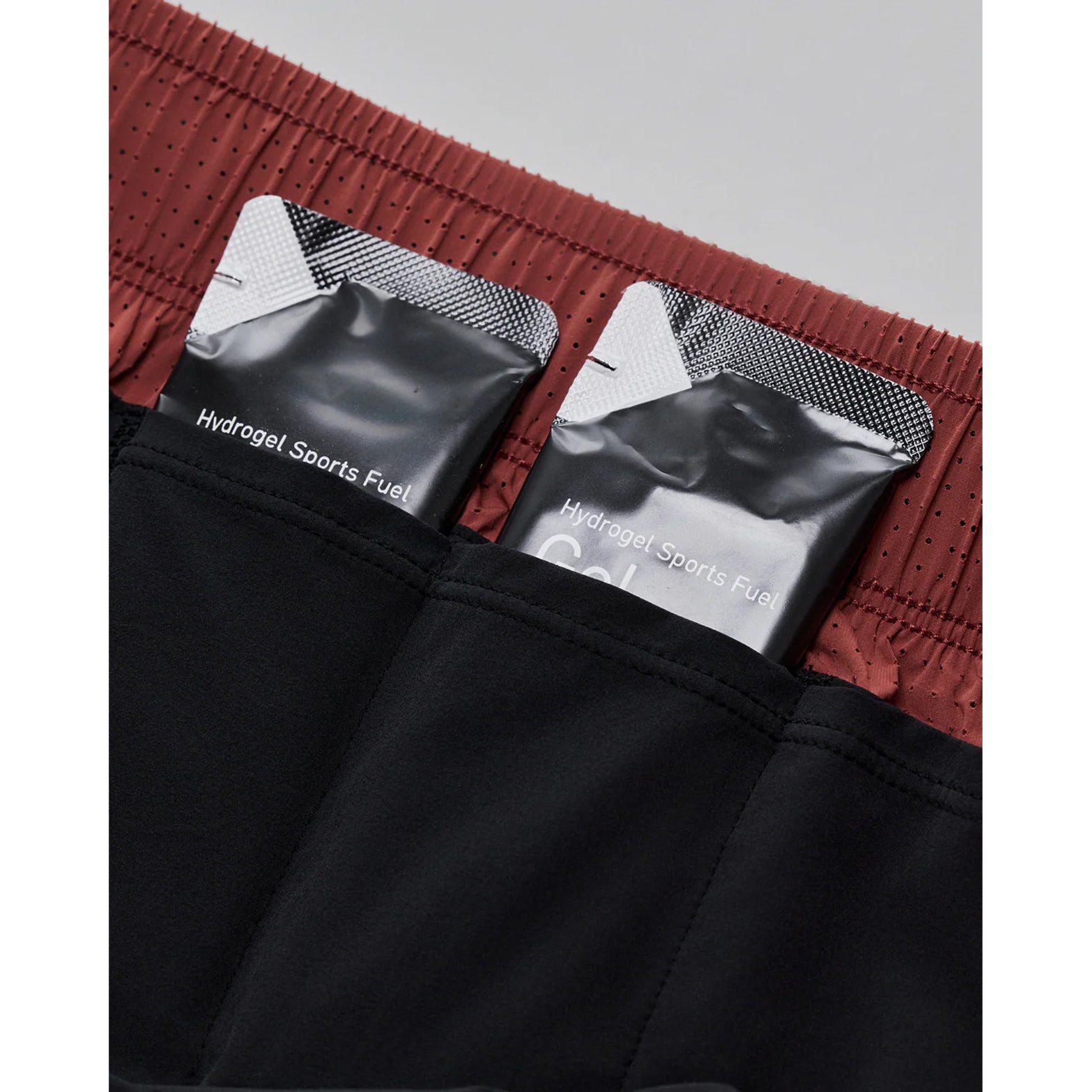 Women's Bandit Vento 2-in-1 Run Short Mahogany Black close-up of 4 gel pockets with key clip showing comprehensive nutrition storage system