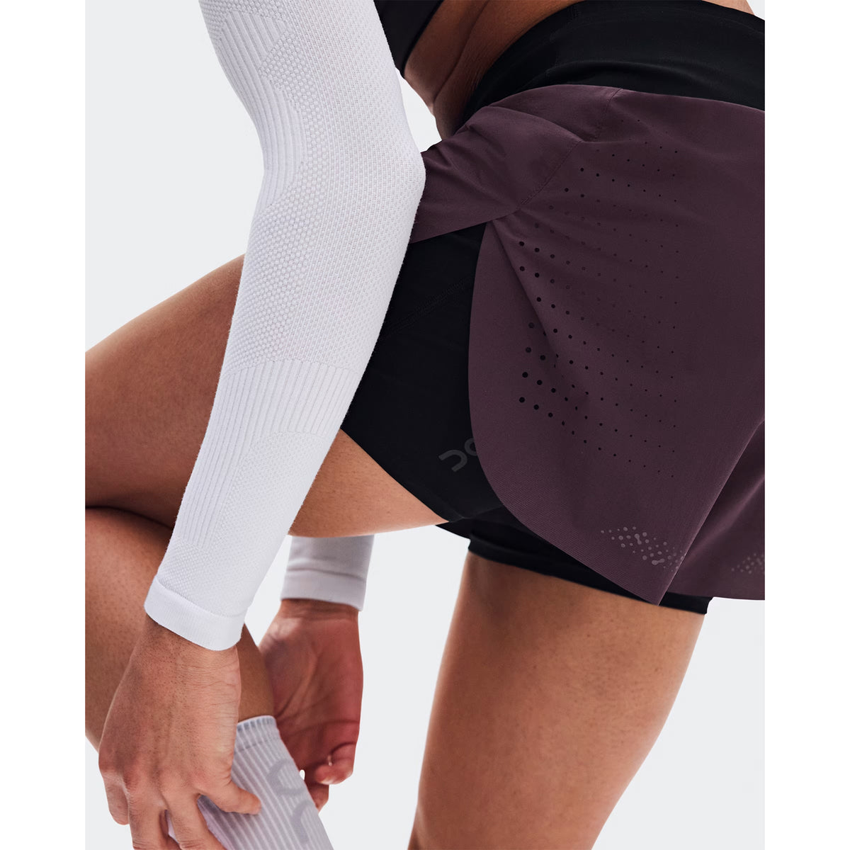 Women's On Zero 2-in-1 Shorts Urchin Black side view on female runner showing ultralight loose outer with On DryTec inner shorts and adjustable drawcord waistband for distraction-free training