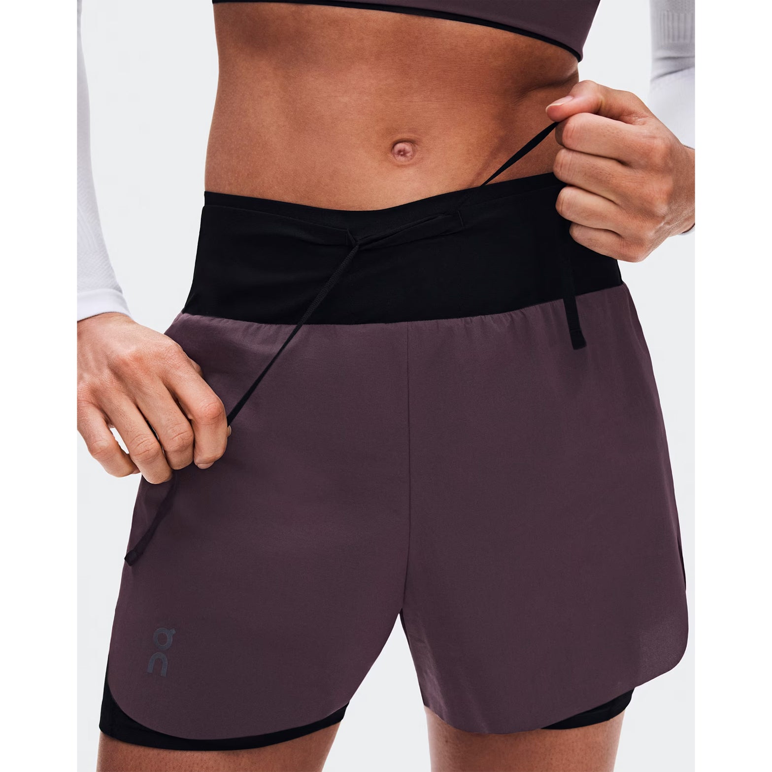 Women's On Zero 2-in-1 Shorts Urchin Black close-up of front showing ultralight perforated outer with On athlete-inspired graphic detail and two-layer waistband construction for high-performance training