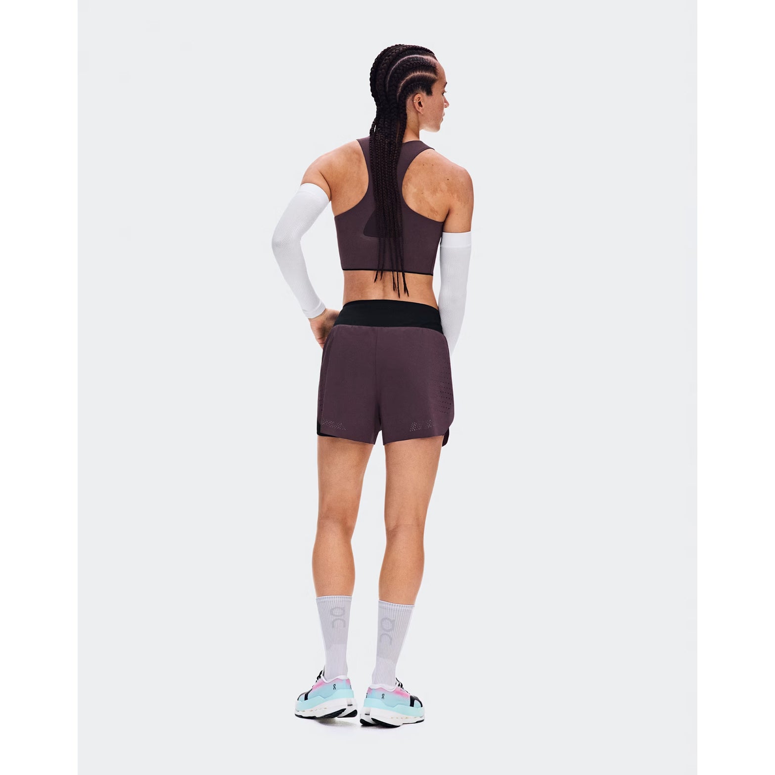Women's On Zero 2-in-1 Shorts Urchin Black back full body view on female runner showing perforated ventilation with zip pocket, gel storage and reflective detailing for practical comfortable training performance