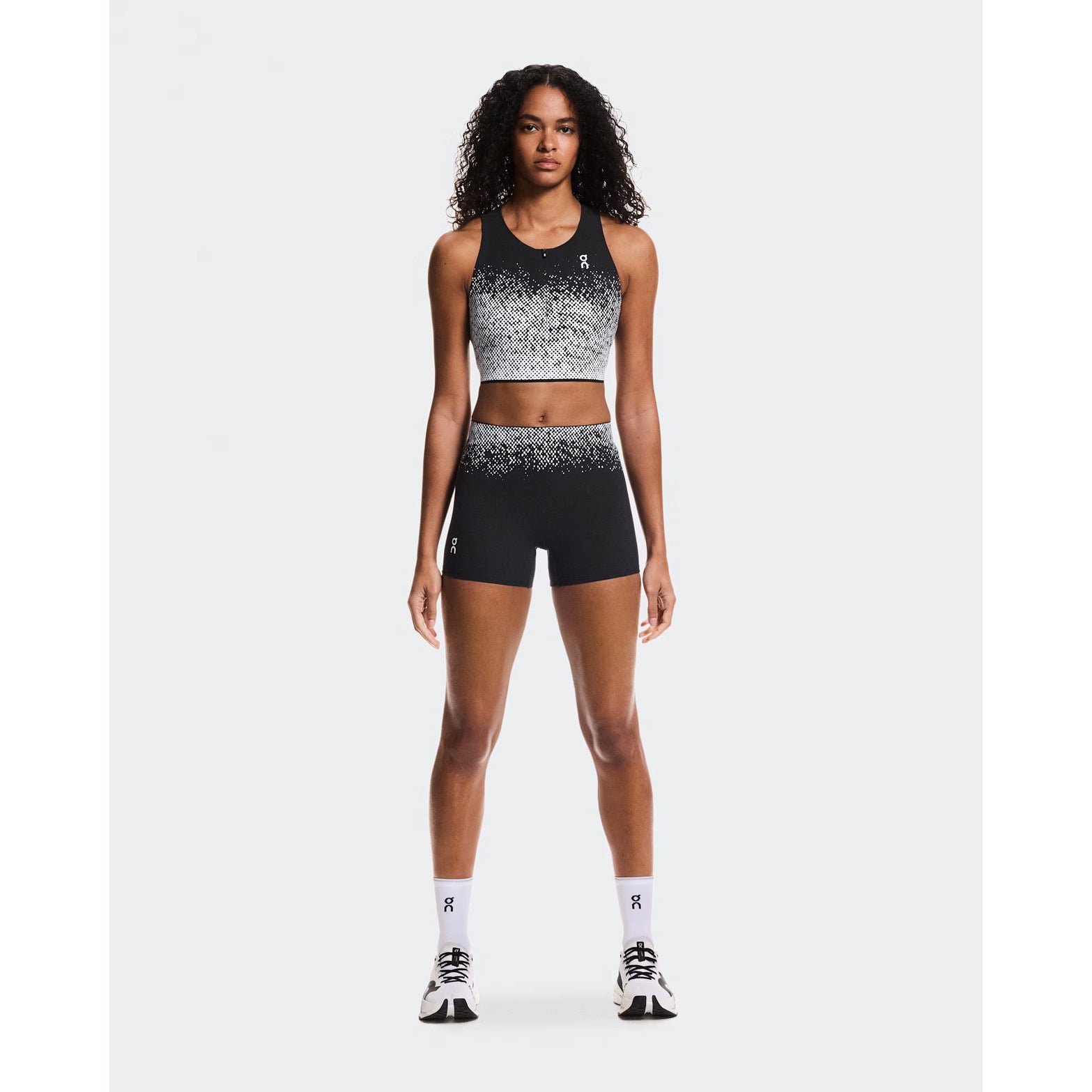 Women's On Zero Crop White Black full body front view on female runner showing built-in support with zip front design for race day and training runs