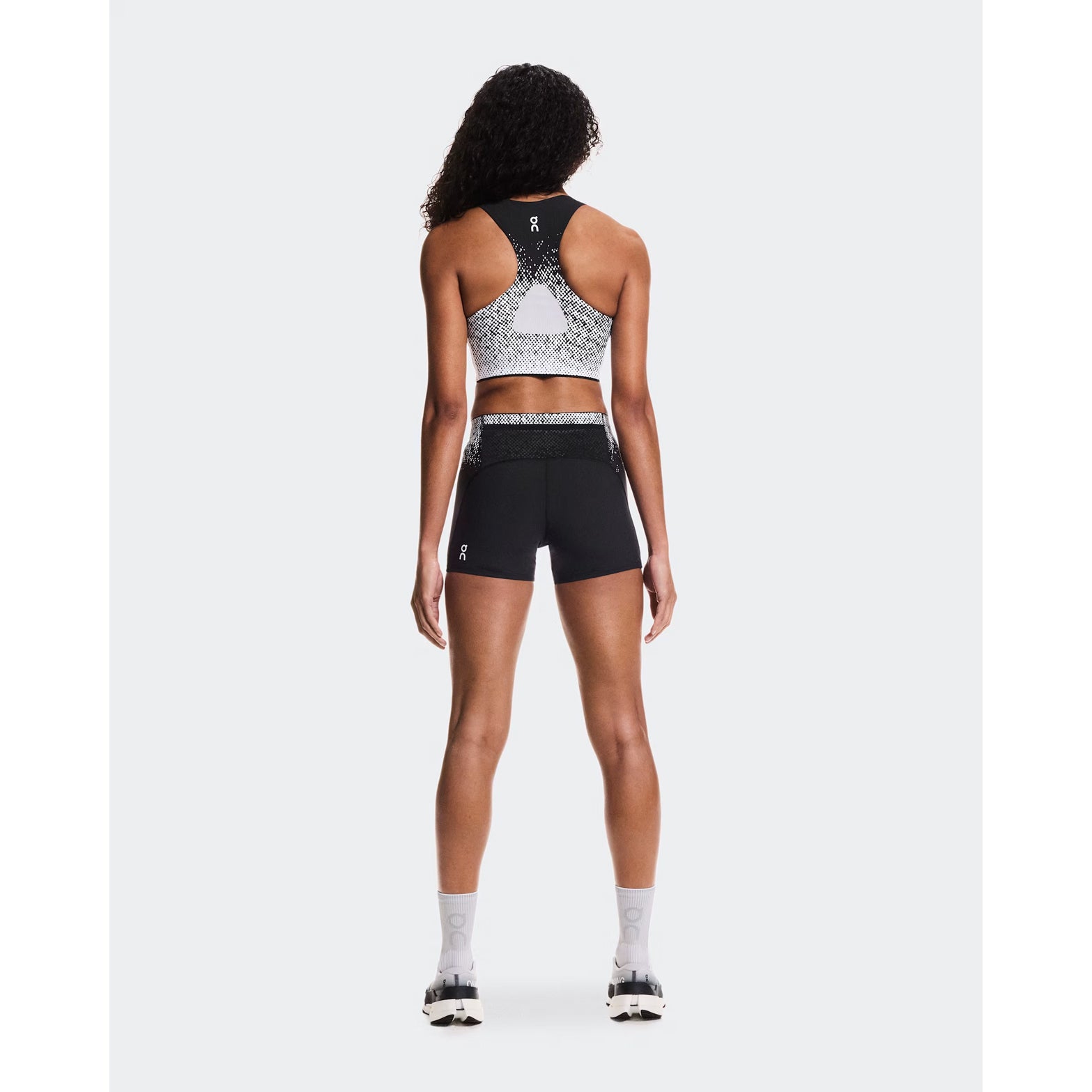 Women's On Zero Crop White Black full body back view on female runner showing mesh back insert for breathability and moisture-wicking construction for comfortable running