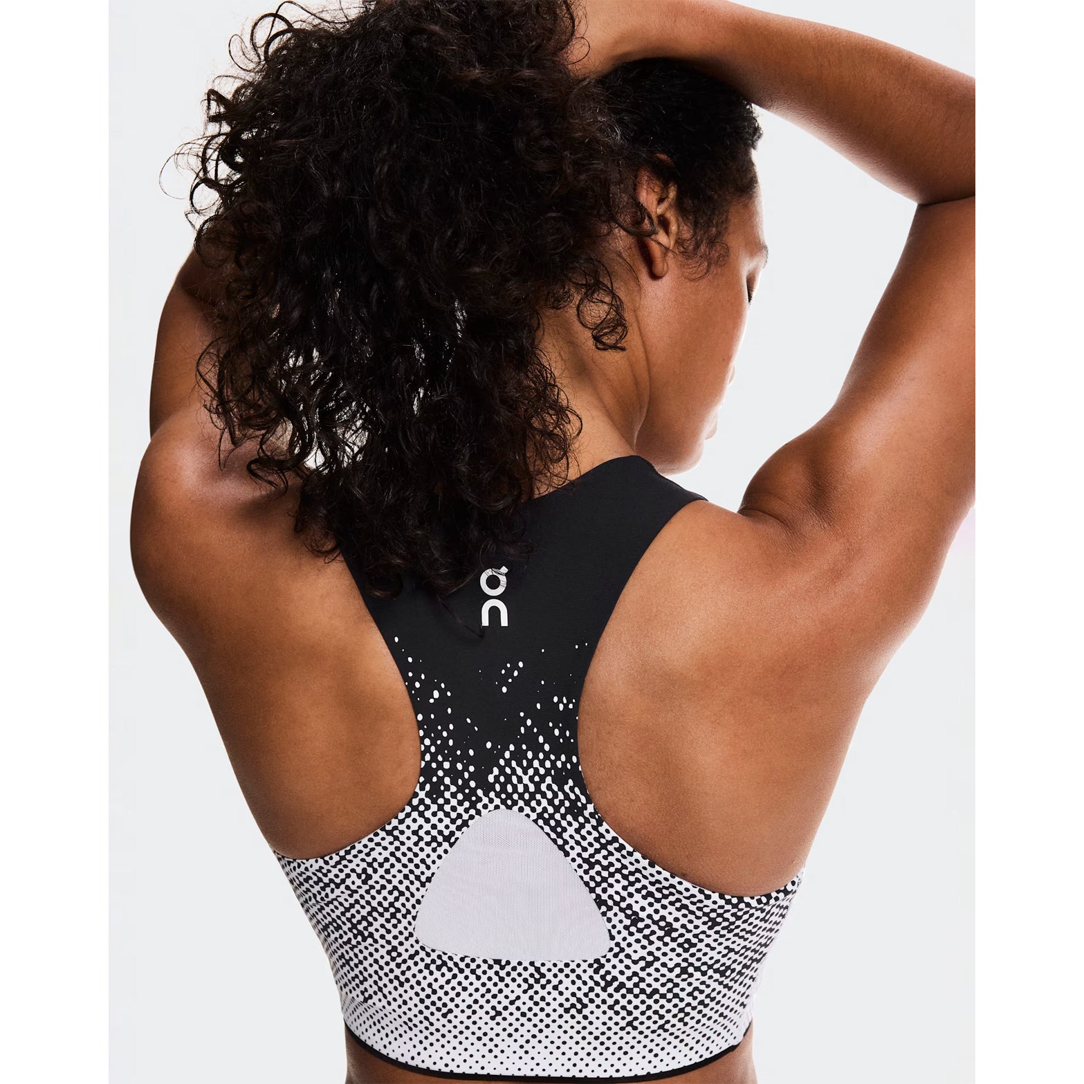 Women's On Zero Crop White Black back view on female runner showing mesh insert for enhanced breathability and expressive athlete-inspired graphics
