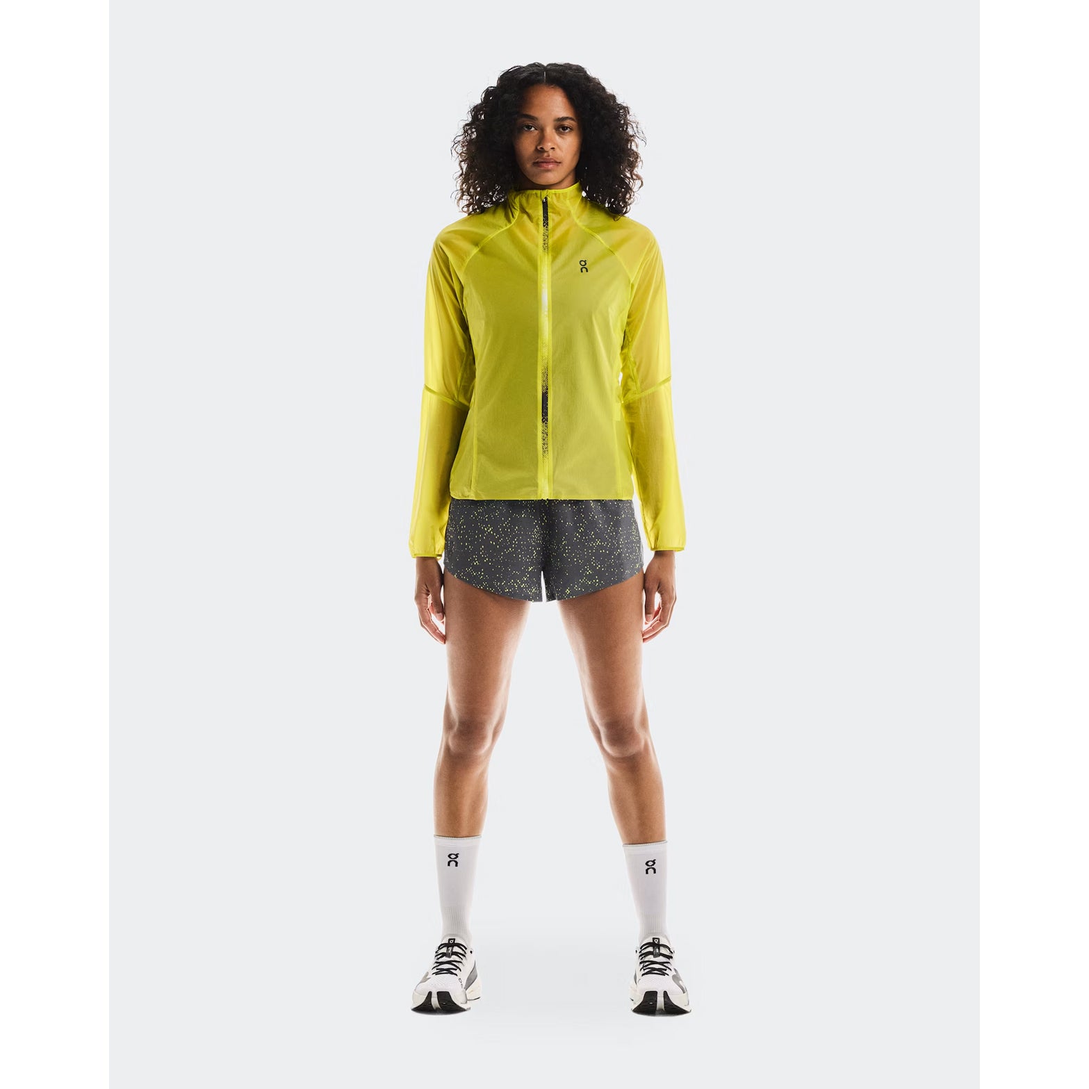 Women's On Zero Jacket Lime full body front view on female runner showing ultralight packable design with windproof water-repellent protection for all-weather running