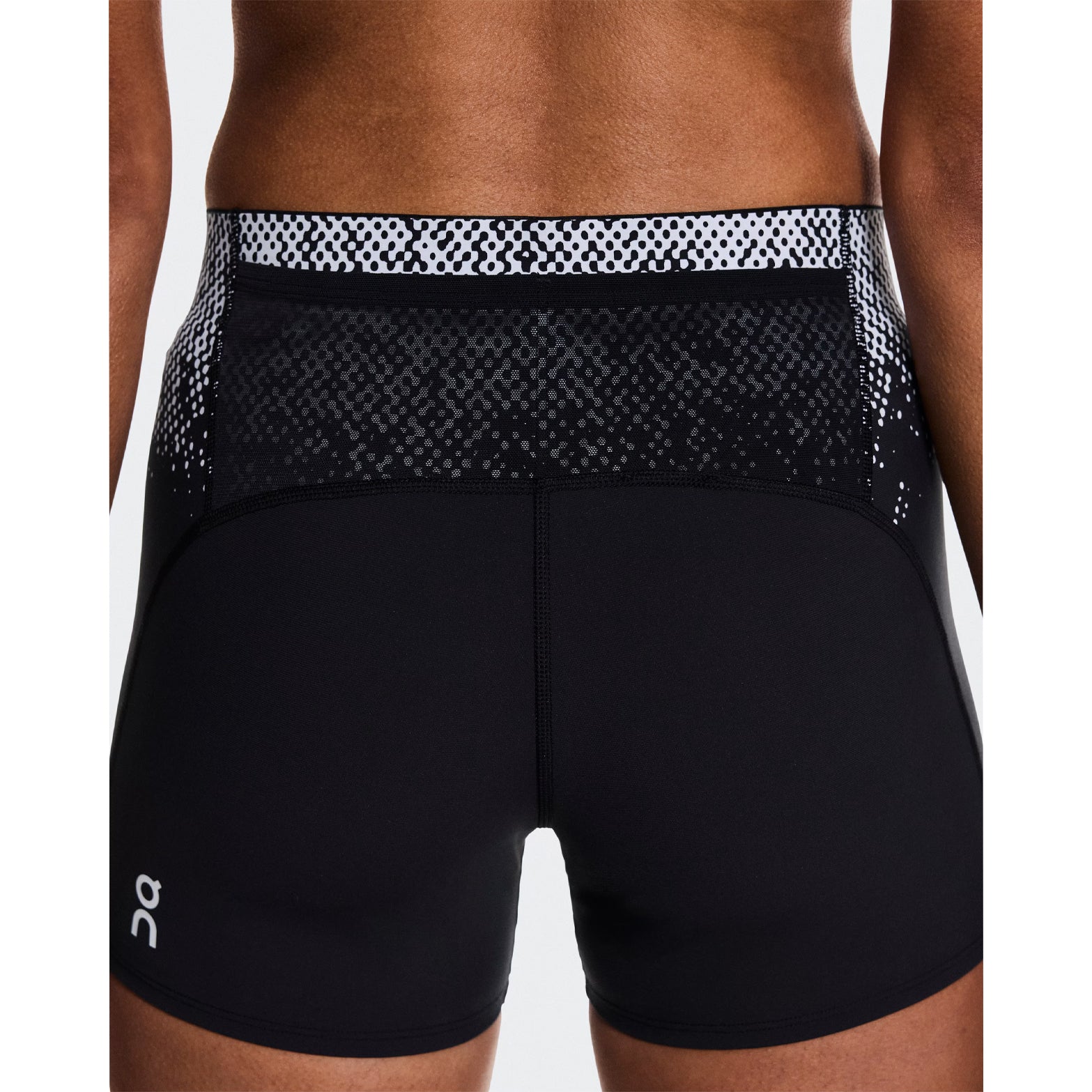 Women's On Zero Short Tights Black White close-up back view on female runner showing back pocket for gel storage and expressive graphic inspired by On athletes