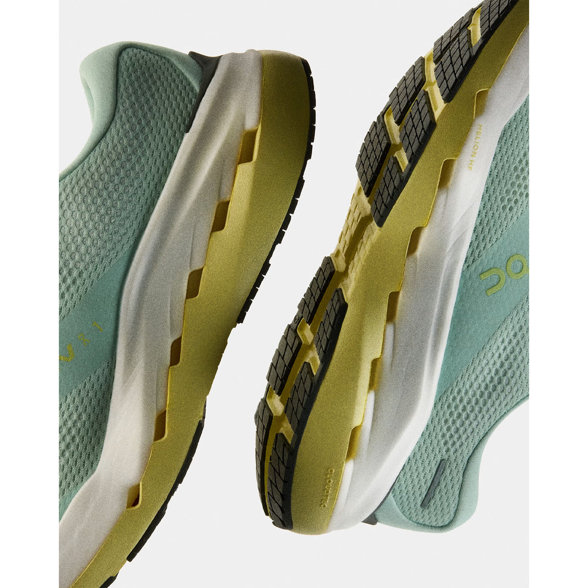 Two mint green and yellow athletic shoes with textured soles are displayed against a white background, showing the sides and bottoms of the shoes.